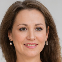 Joyful white young-adult female with long  brown hair and grey eyes