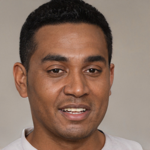 Joyful black young-adult male with short  brown hair and brown eyes