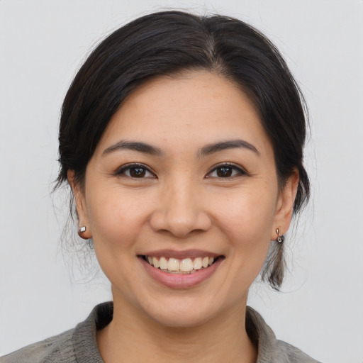 Joyful asian young-adult female with medium  brown hair and brown eyes