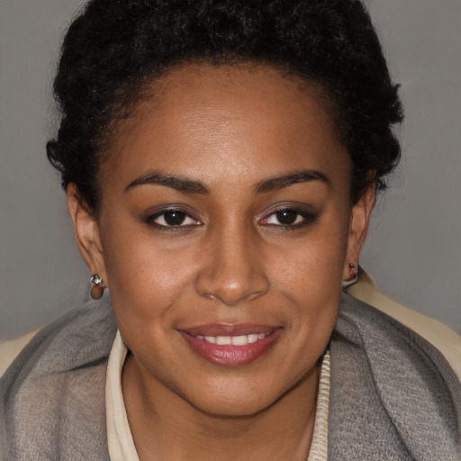 Joyful black young-adult female with short  brown hair and brown eyes