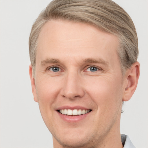 Joyful white adult male with short  brown hair and grey eyes