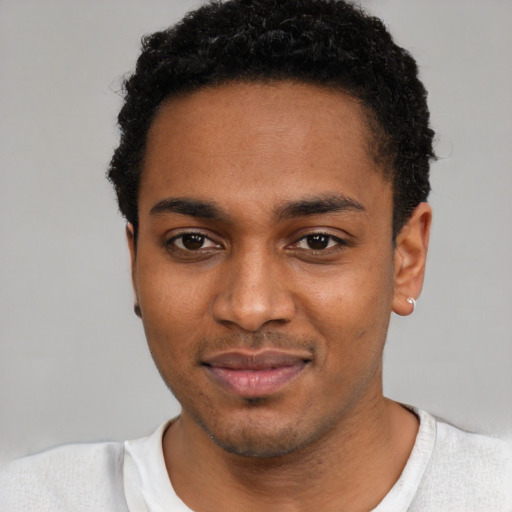Joyful black young-adult male with short  black hair and brown eyes