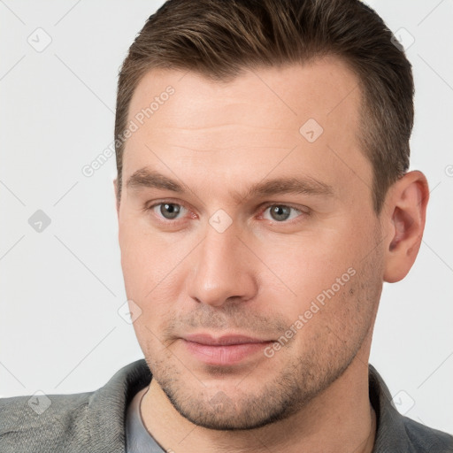 Joyful white young-adult male with short  brown hair and brown eyes