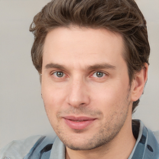 Joyful white young-adult male with short  brown hair and grey eyes