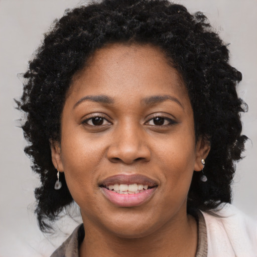 Joyful black young-adult female with long  brown hair and brown eyes