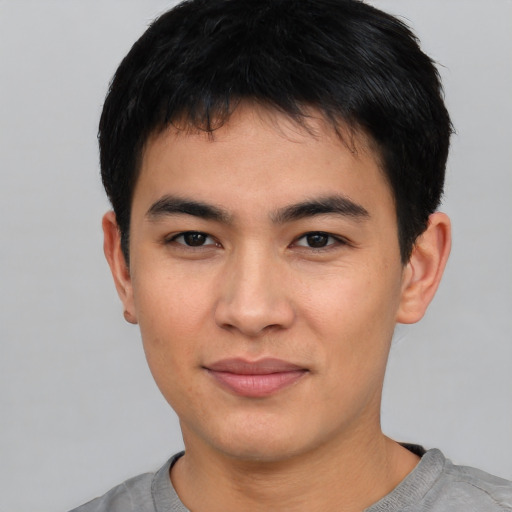 Joyful asian young-adult male with short  brown hair and brown eyes