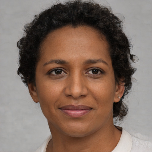 Joyful black adult female with short  brown hair and brown eyes