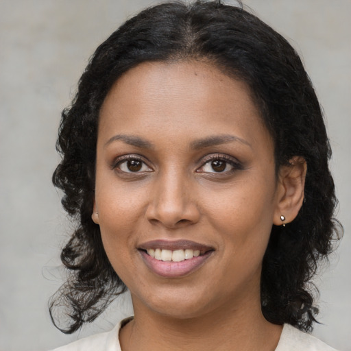 Joyful black young-adult female with medium  brown hair and brown eyes