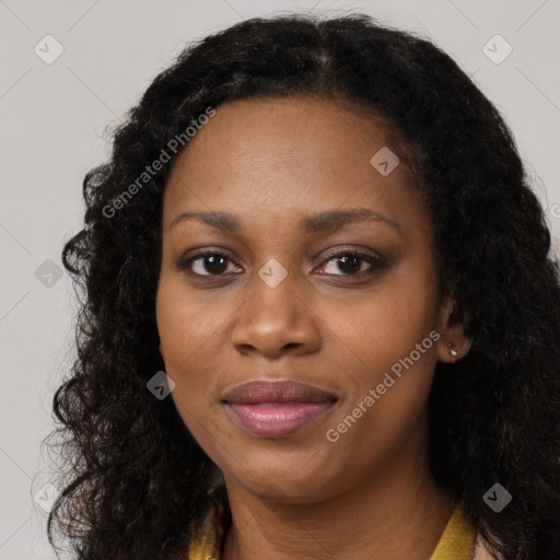 Joyful black young-adult female with long  black hair and brown eyes