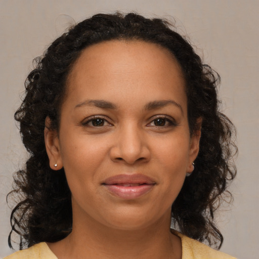 Joyful latino young-adult female with medium  brown hair and brown eyes