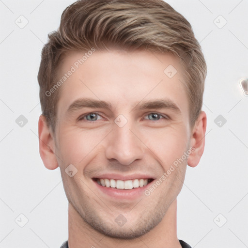 Joyful white young-adult male with short  brown hair and grey eyes