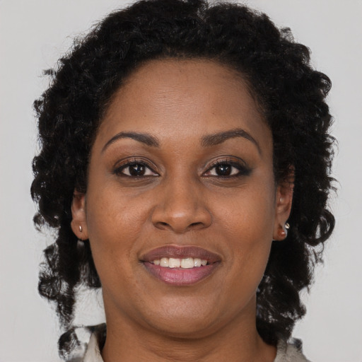 Joyful black adult female with long  brown hair and brown eyes