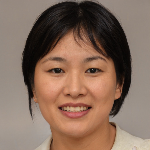 Joyful asian young-adult female with medium  brown hair and brown eyes