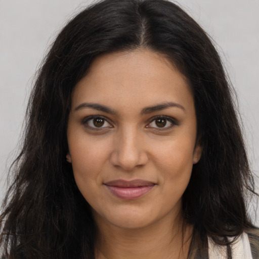 Joyful latino young-adult female with long  brown hair and brown eyes