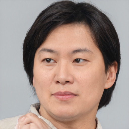 Joyful asian adult male with medium  brown hair and brown eyes