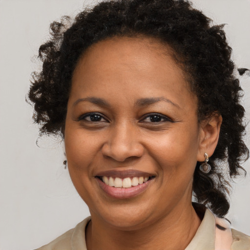 Joyful black adult female with medium  brown hair and brown eyes