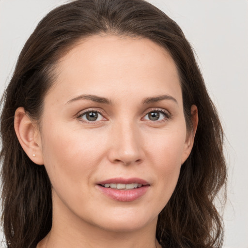 Joyful white young-adult female with long  brown hair and brown eyes