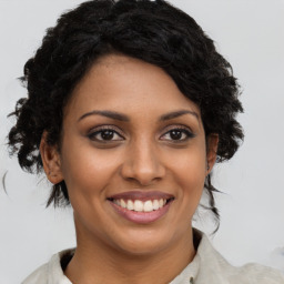 Joyful black young-adult female with medium  brown hair and brown eyes