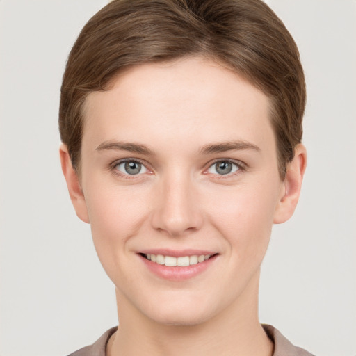 Joyful white young-adult female with short  brown hair and grey eyes