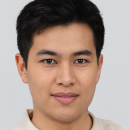 Joyful asian young-adult male with short  brown hair and brown eyes