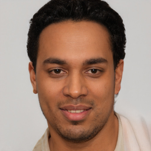 Joyful latino young-adult male with short  black hair and brown eyes