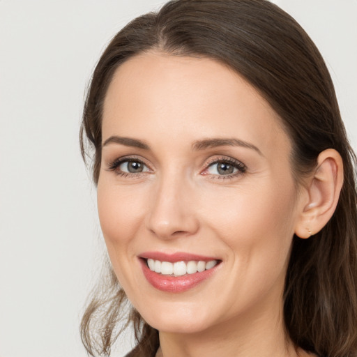 Joyful white young-adult female with long  brown hair and grey eyes