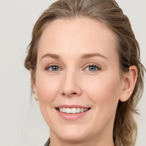 Joyful white young-adult female with medium  brown hair and blue eyes