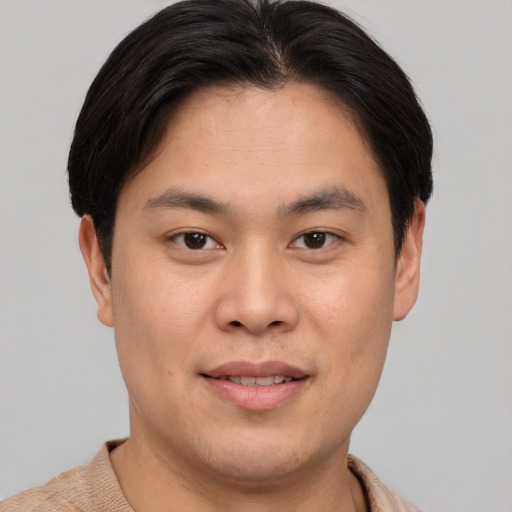 Joyful asian young-adult male with short  brown hair and brown eyes