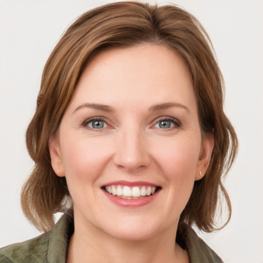 Joyful white young-adult female with medium  brown hair and green eyes