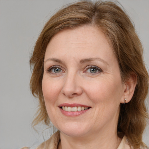 Joyful white adult female with medium  brown hair and blue eyes