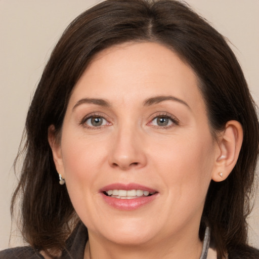 Joyful white adult female with medium  brown hair and brown eyes