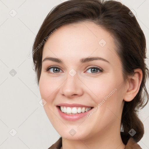 Joyful white young-adult female with medium  brown hair and grey eyes