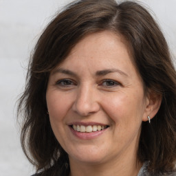 Joyful white adult female with medium  brown hair and brown eyes