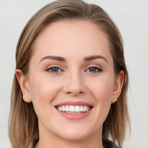 Joyful white young-adult female with long  brown hair and blue eyes