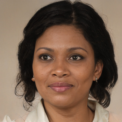 Joyful black adult female with medium  brown hair and brown eyes