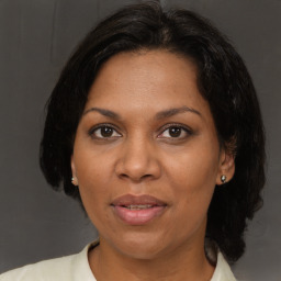 Joyful black adult female with medium  brown hair and brown eyes