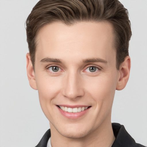 Joyful white young-adult male with short  brown hair and grey eyes