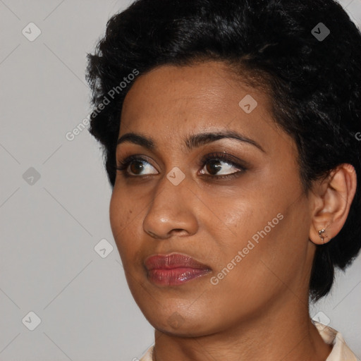 Joyful black young-adult female with short  black hair and brown eyes