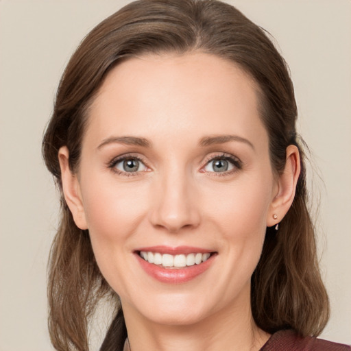 Joyful white young-adult female with medium  brown hair and blue eyes