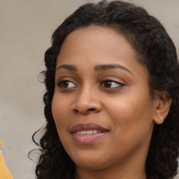 Joyful black young-adult female with long  brown hair and brown eyes