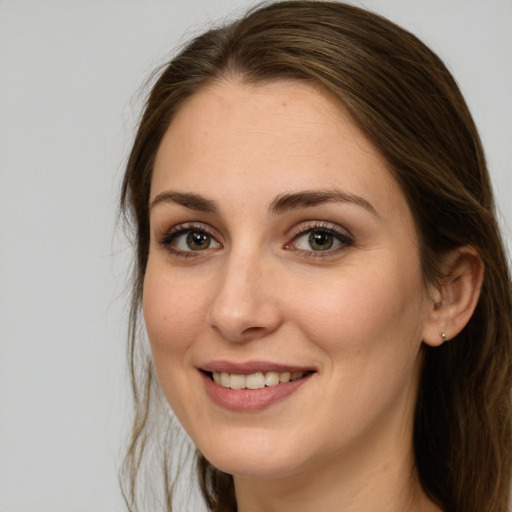 Joyful white young-adult female with long  brown hair and green eyes