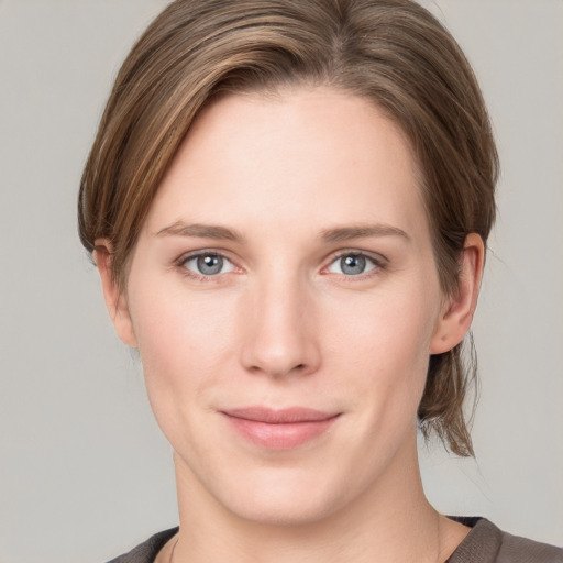 Joyful white young-adult female with medium  brown hair and grey eyes