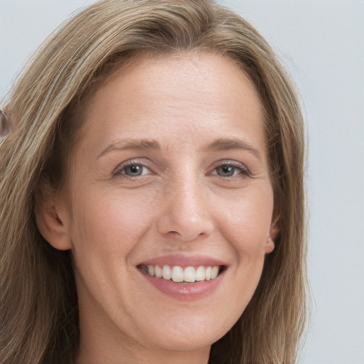 Joyful white adult female with long  brown hair and grey eyes