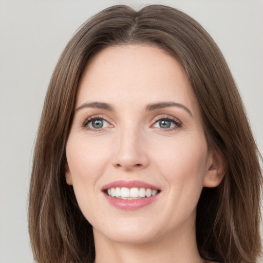 Joyful white young-adult female with long  brown hair and grey eyes