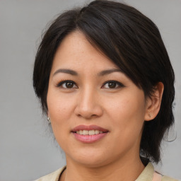 Joyful asian young-adult female with medium  brown hair and brown eyes