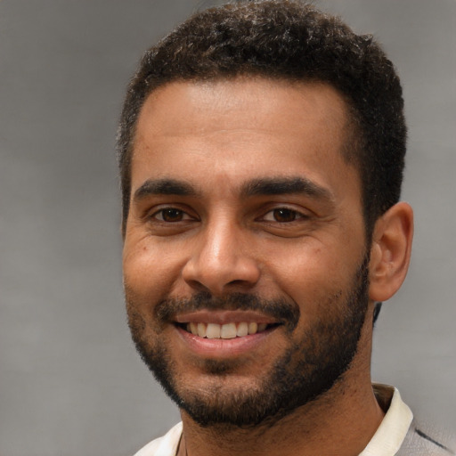 Joyful black young-adult male with short  brown hair and brown eyes