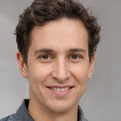 Joyful white adult male with short  brown hair and grey eyes