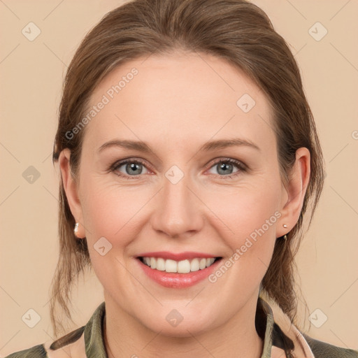 Joyful white young-adult female with medium  brown hair and grey eyes