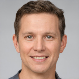 Joyful white adult male with short  brown hair and grey eyes