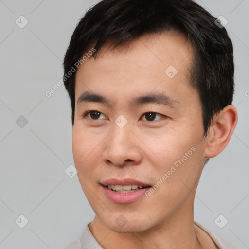 Joyful asian young-adult male with short  black hair and brown eyes